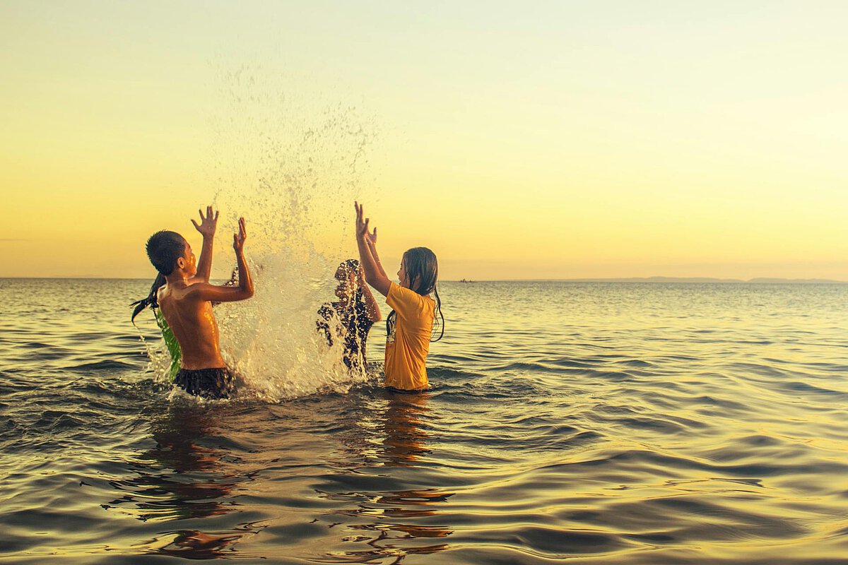 A group of children play by the sea in the Algarve in the late afternoon.