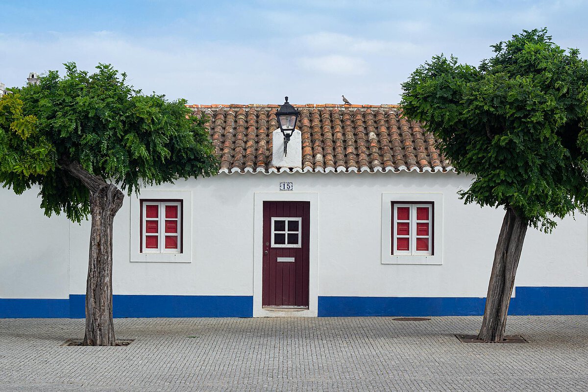 A typical housing construction in Setubal, Portugal, with white wall and tinted windows.